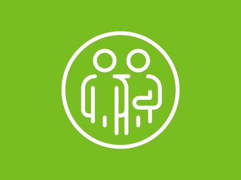 Icon of two people outlined in white within a circle on a green background, representing support or coaching.