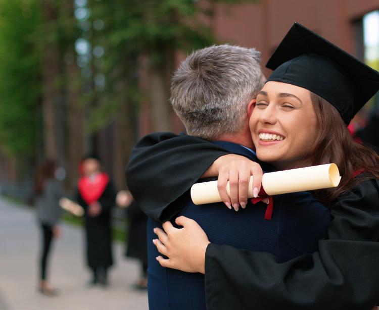 Female college grad hugging her father
